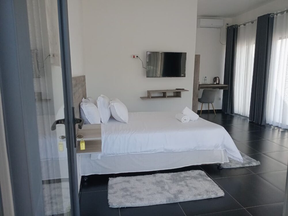 Quarto casal com cama de casal, televisão e secretária