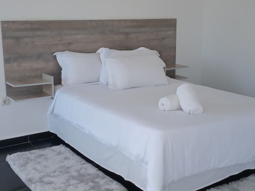 Cama de casal com roupa branca e toalhas