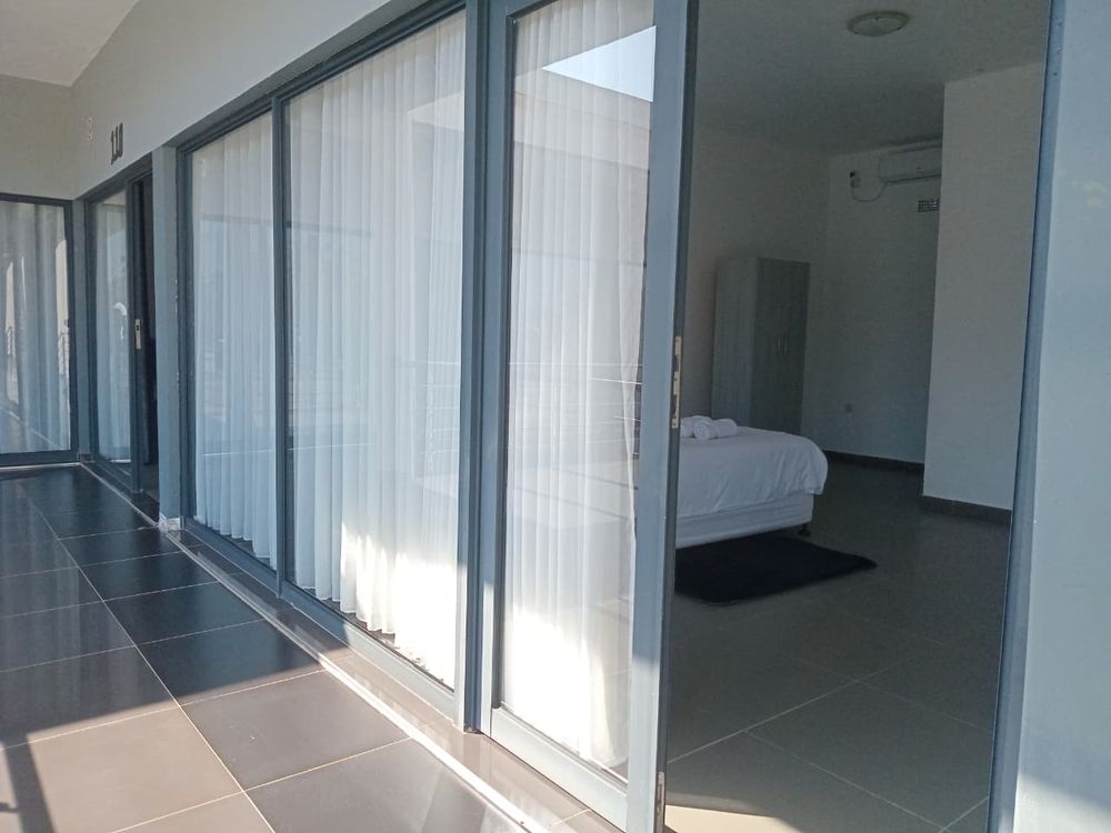 Quarto visto do corredor, com portas de vidro e cortinas